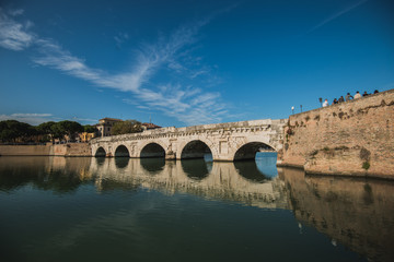 Fototapeta na wymiar Rimini, Italy - September 11, 2019: Tiberius bridge in Rimini on a background of blue sky with white clouds