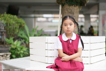 Asian child cute or kid girl and student big eye with shorten mouth or pucker up with happy cheerful and wear school uniform for education and back to school or go to school at kindergarten or nursery