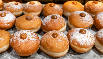 Fresh donuts  with chocolate at the bakery display for Hanukkah celebration. Selective focus.