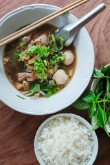 Braised beef noodle with pork ball on wooden table.