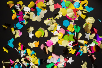 top view multicolored confetti mess on a black background,abstract holiday background