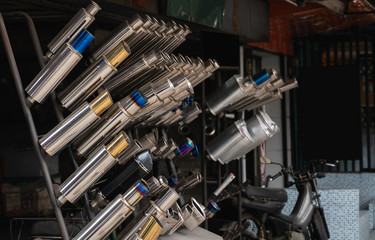 New and used motorcycle exhaust chrome pipes in a motorcykles shop or in service center.