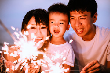 happy family celebrating new year with sparklers