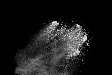White powder explosion isolated on black background.White dust particles splash.