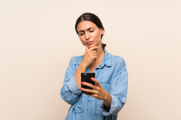 Young woman over isolated background thinking and sending a message
