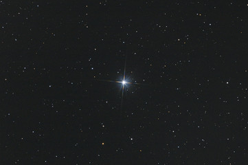 Closeup of the star Sadr in Cygnus constellation, with many stars as background in the deep space.