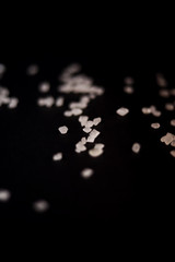 White transparent sugar as stones isolated on black background. Pieces of sweet macro candies for design,
