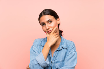 Young woman over isolated pink background thinking an idea