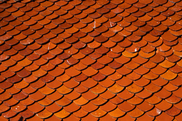 Natural orange roof tiles on a building as a texture.