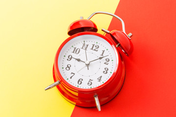 Alarm clock on the red and yellow background