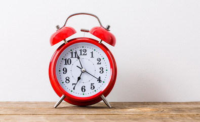 Old red alarm clock, showing seven o`clock time to wake up