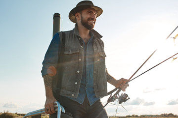 Caucasian adult father look like real fisherman inspect place for fishing. the sun shining