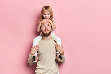 young good looking kind fatherhaving fun with his little child, close up portrait, isolated pink...