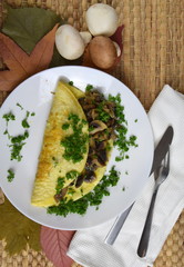 tasty mushroom omelette decorated with coloured leaves on brown background