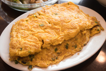 Closeup of omelette with fresh green onion, scrambled eggs