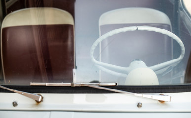 Vintage car interior and white steering wheel.