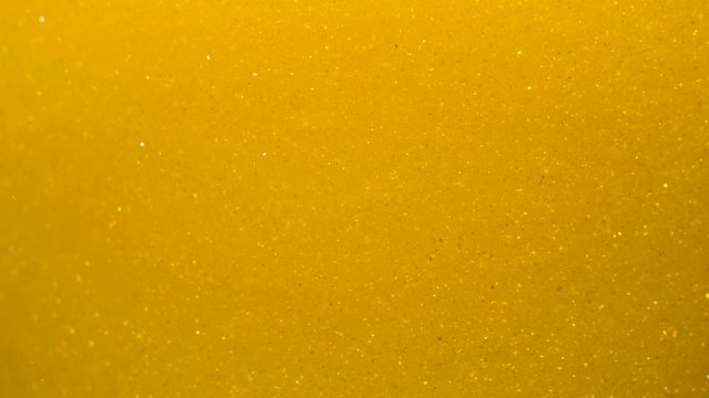Golden Wave Background. Art Gold Background. Golden Sand , Dust Creating Abstract Cloud Formations. Slow Motion. Gold Texture. Amazing Metamorphosis Sparkle Shiny Particles Flow With Underwater.
