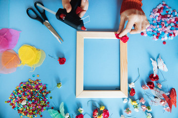 the master of decor decorates the photo frame with various colors and beauty objects, the decorator...