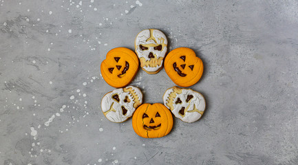 Jack O Lanterns pumpkin shaped cookies and skull shaped cookies with a glass of milk. Halloween kids breakfast.