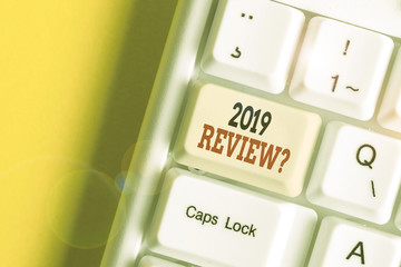 Conceptual hand writing showing 2019 Review Question. Concept meaning remembering past year events main actions or good shows White pc keyboard with note paper above the white background