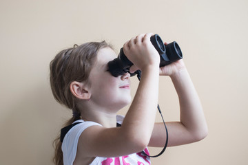 little girl with binoculars on a light background