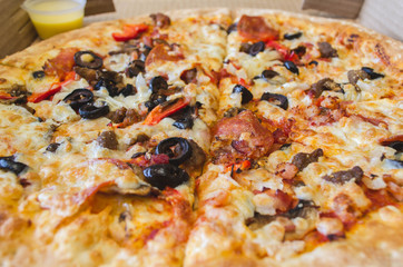 pizza with olives and pepperoni sausage close-up