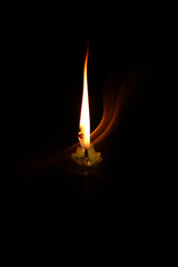 light candle burning brightly in the black background.