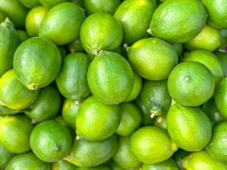 Fresh ripe green limes as background. Lime Citrus Fruits In Fruit Market