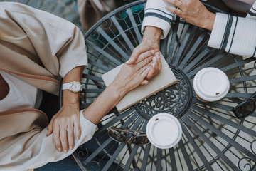 Caucasian woman holding her female friends hand