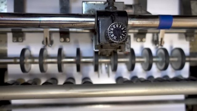 Machines in the printing house, closeup shoot. Newspapers coming off the rotation printing folder in press industrial