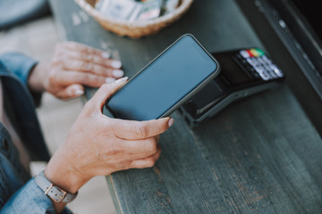 Caucasian female hand paying through a smartphone