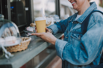 Senior lady buying a cup of coffee