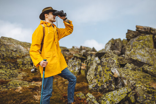 Young Adventurous Tourist Reached The Summit Of Mountains And Using Binoculars, Close Up Side View Photo. Copy Space