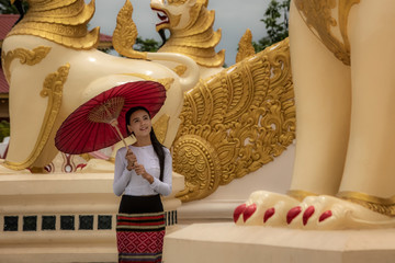 A beautiful Burmese girl wearing a national costume for a walk, inside the Shwedagon Pagoda of Yangon, Myanmar.