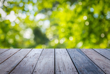 Old wood plank with abstract natural green blurred bokeh background for product display