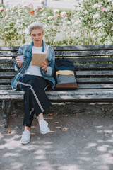 Focused lady reading a book on the bench