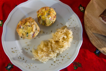 two knodels on the plate with sauerkraut and speck on the background and mug of beer and Christmas tablecloth