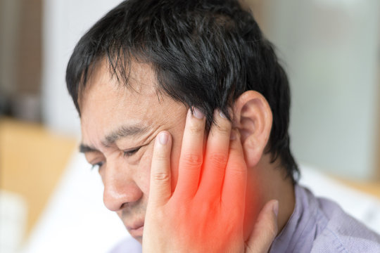 TMD and TMJ healthcare concept: Temporomandibular Joint and Muscle Disorder. Asia man hand on cheek face as suffering from facial pain, mumps or toothache