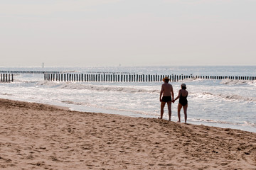 couple walking on the beach at sunset