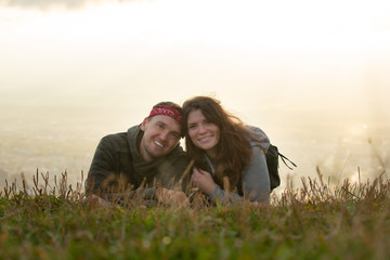 Couple in love lying at the top of the mountain and watching autumn landscape. Sunset