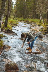 young hiker draws cold water into his cup, full length side view photo.break