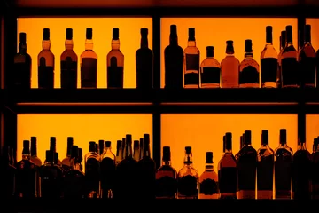 Poster Bottles sitting on shelf in a bar © Kondor83