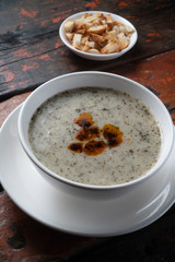 Traditional Turkish yogurt soup with croutons aside isolated on rustic wooden table
