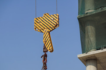 Obraz premium Closeup view of crane hook against blue sky