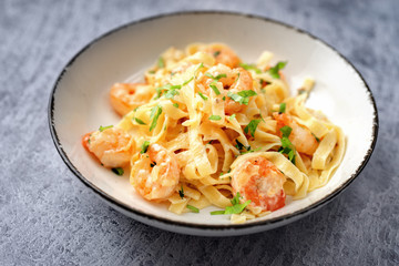 Close up of shrimp fettuccine alfredo on blue background