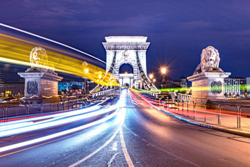 The Chain Bridge in Budapest at night. Moving lights of the cars.