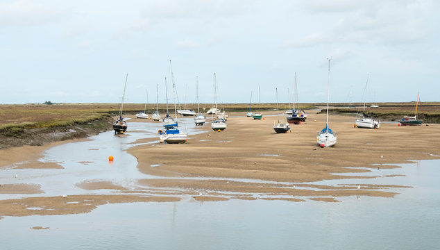 Small boats at low tide at Wells next the Sea, Norfolk, UK