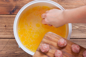 Step by step cooking homemade meatball soup, step 2 adding meatballs, selective focus, top view