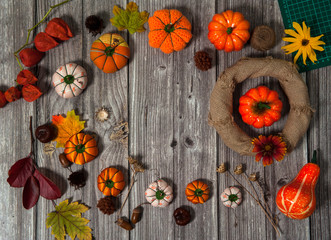 Composition for thanksgiving. Making decorations on the door of textile gourds handmade and natural materials.  Wreath, autumn leaves, cones and acorns on a wooden background.