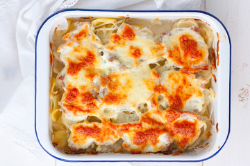 Baked sliced potatoes with pork and cheese, top view, selective focus
